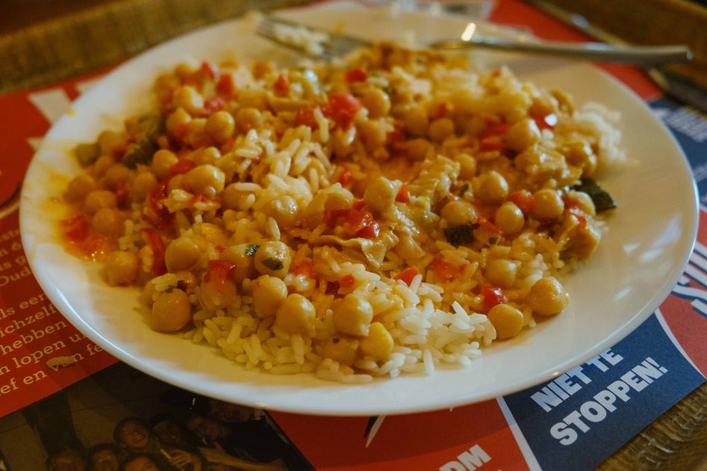 Bord met rijst, kikkererwten, groente en een sausje
