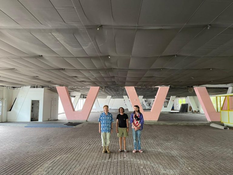 Members of OEB pose in the empty space under the bridge, giving a sense of the size.