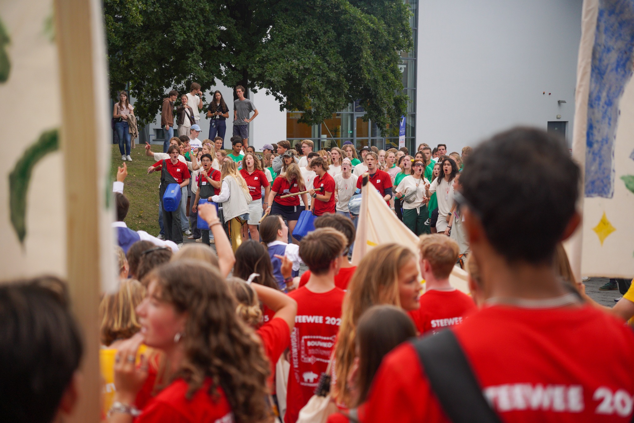 Twee groepen studenten staan tegenover elkaar.