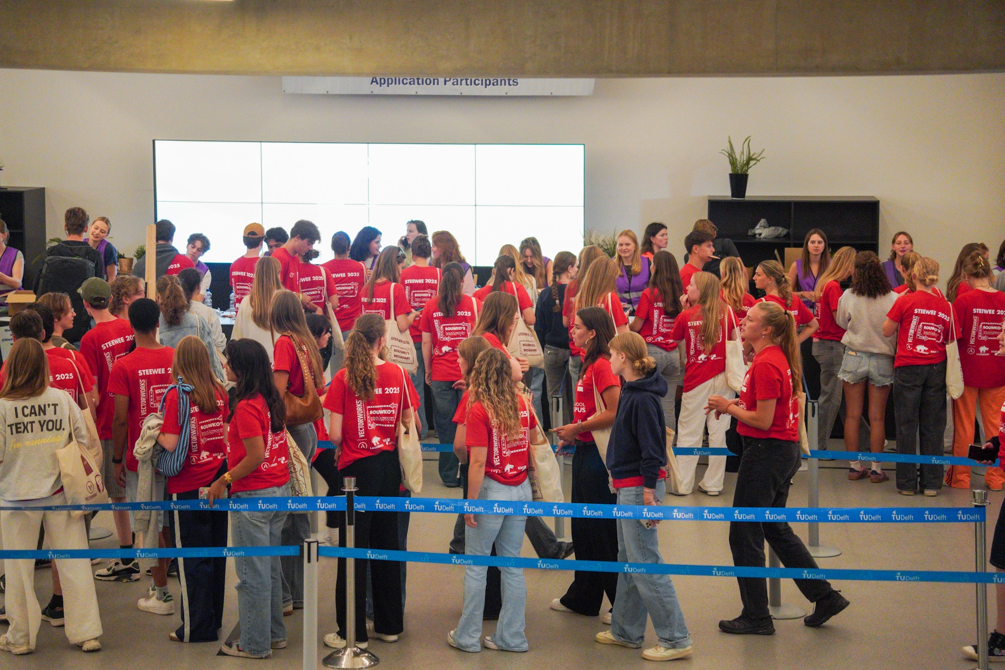 Studenten met rode shirts staan in de rij