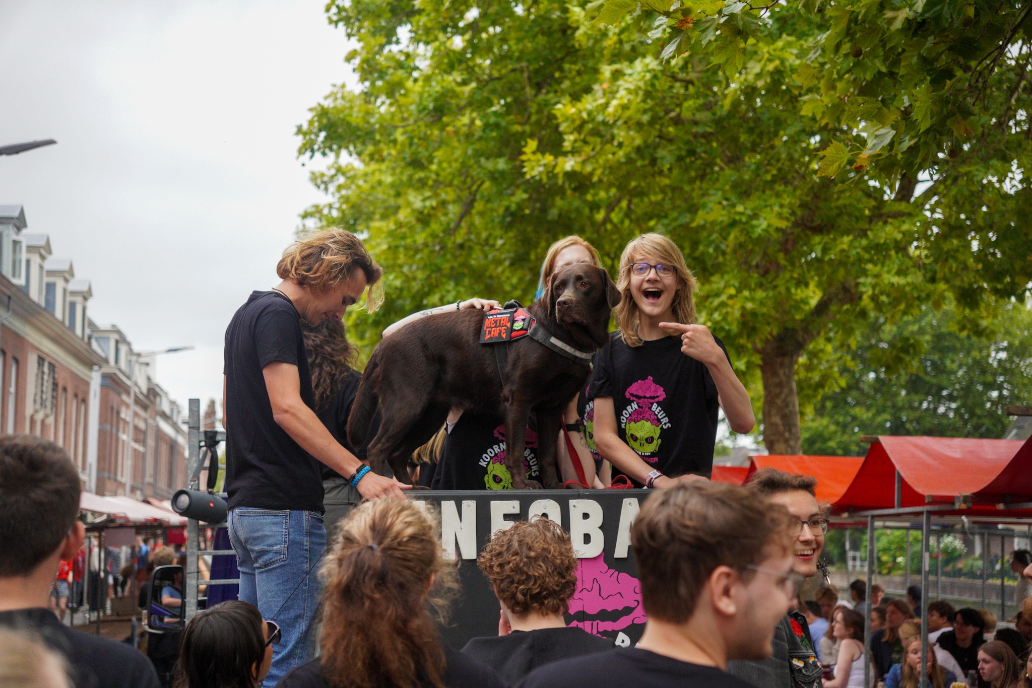 Studenten staan op een kar. Ze hebben een hond bij zich.