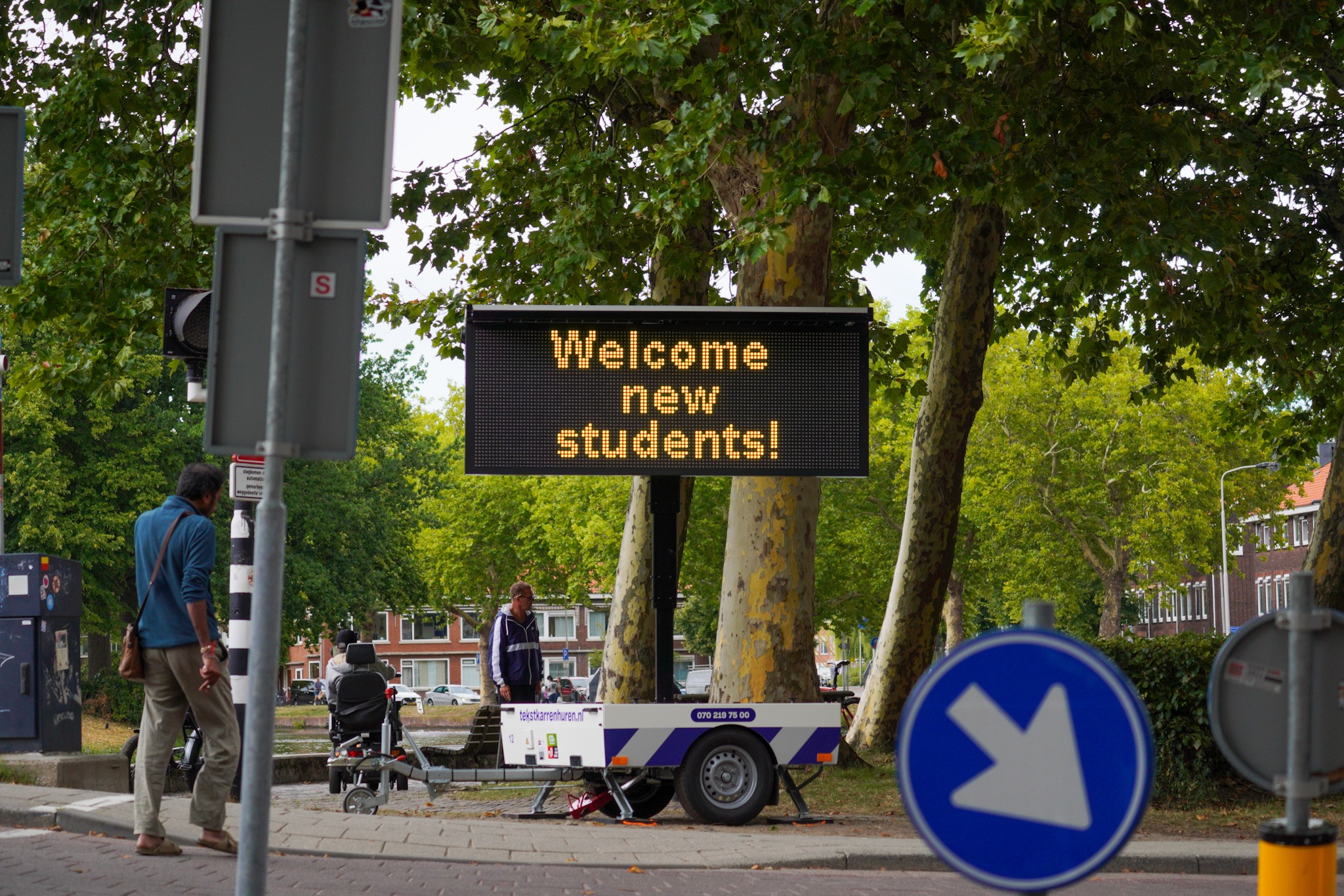 Een bord met Welcome new students! staat op straat