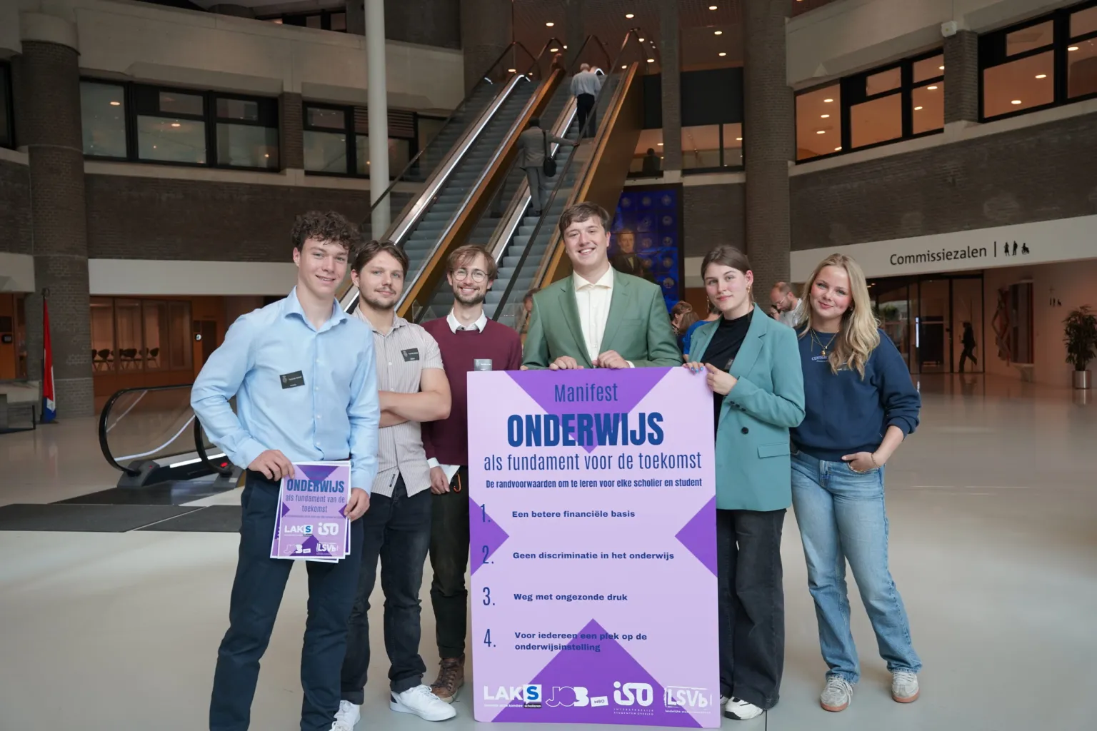 Studenten en scholieren poseren met een bord waar op staat 'Manifest als fundament voor de toekomst'