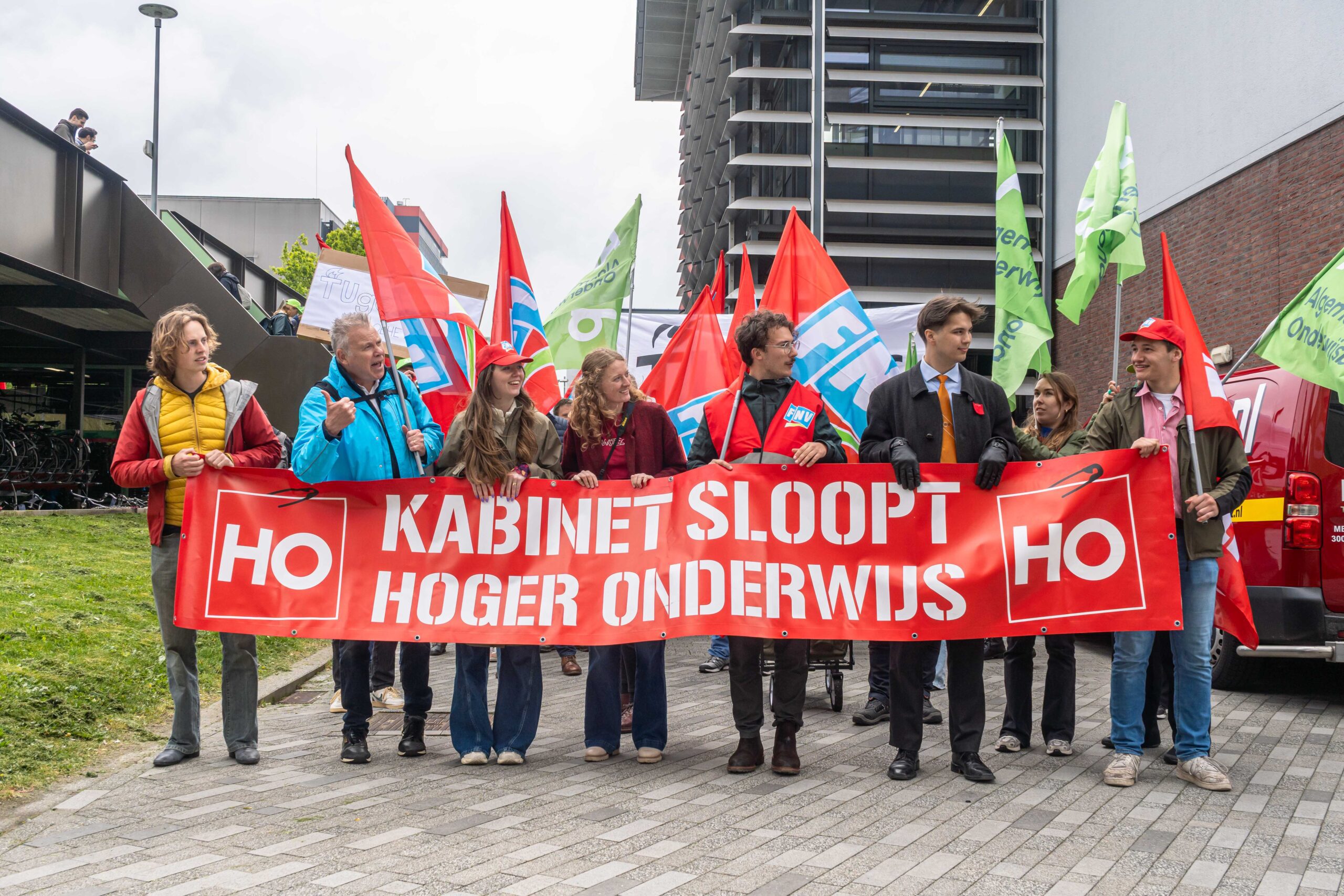 Education must partially absorb inflation itself Mensen lopen met een spandoek en vlaggen. op het spandoek staat Kaninet sloopt hoger onderwijs