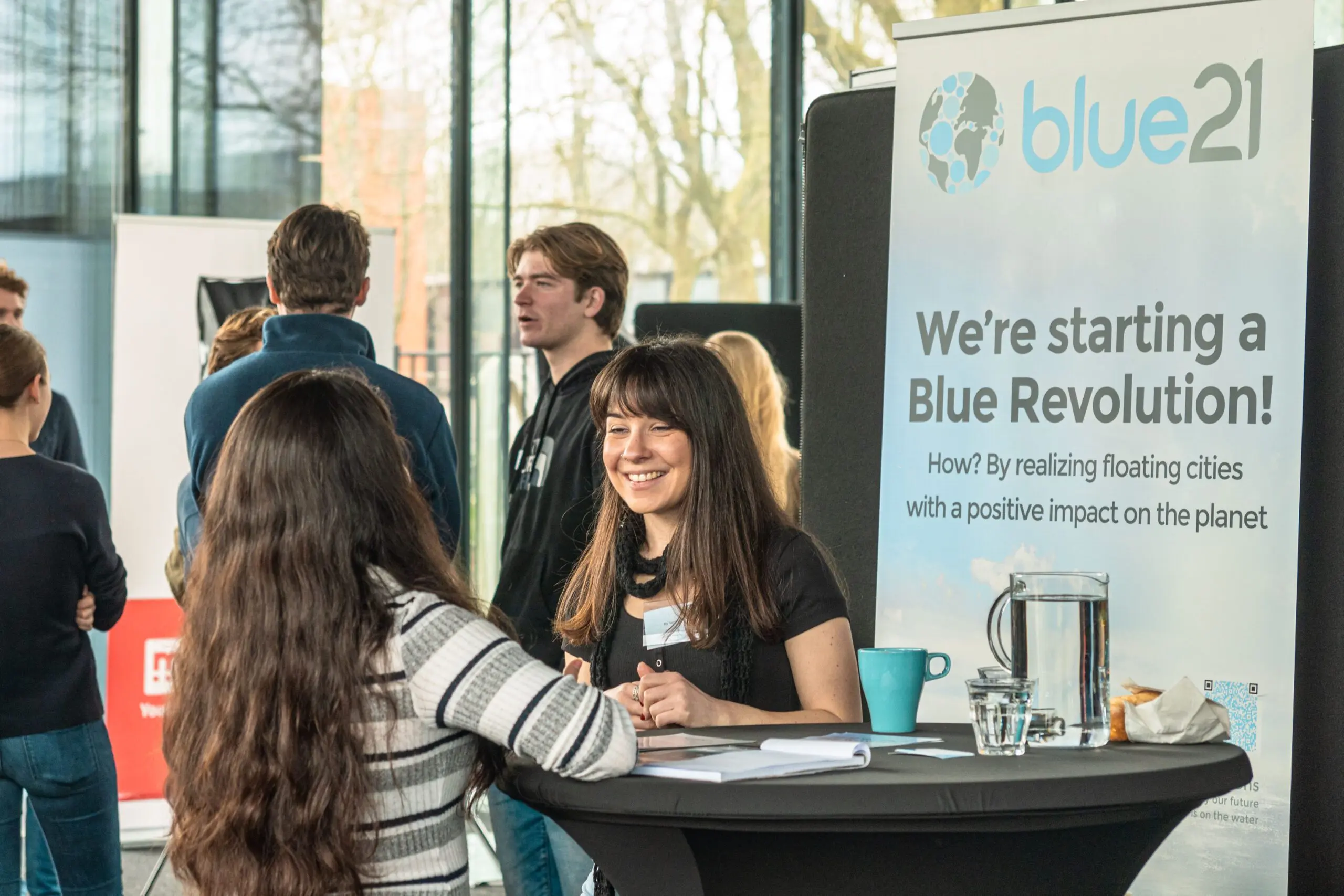 Jonge mensen praten met elkaar aan een statafel op de Green Career Days