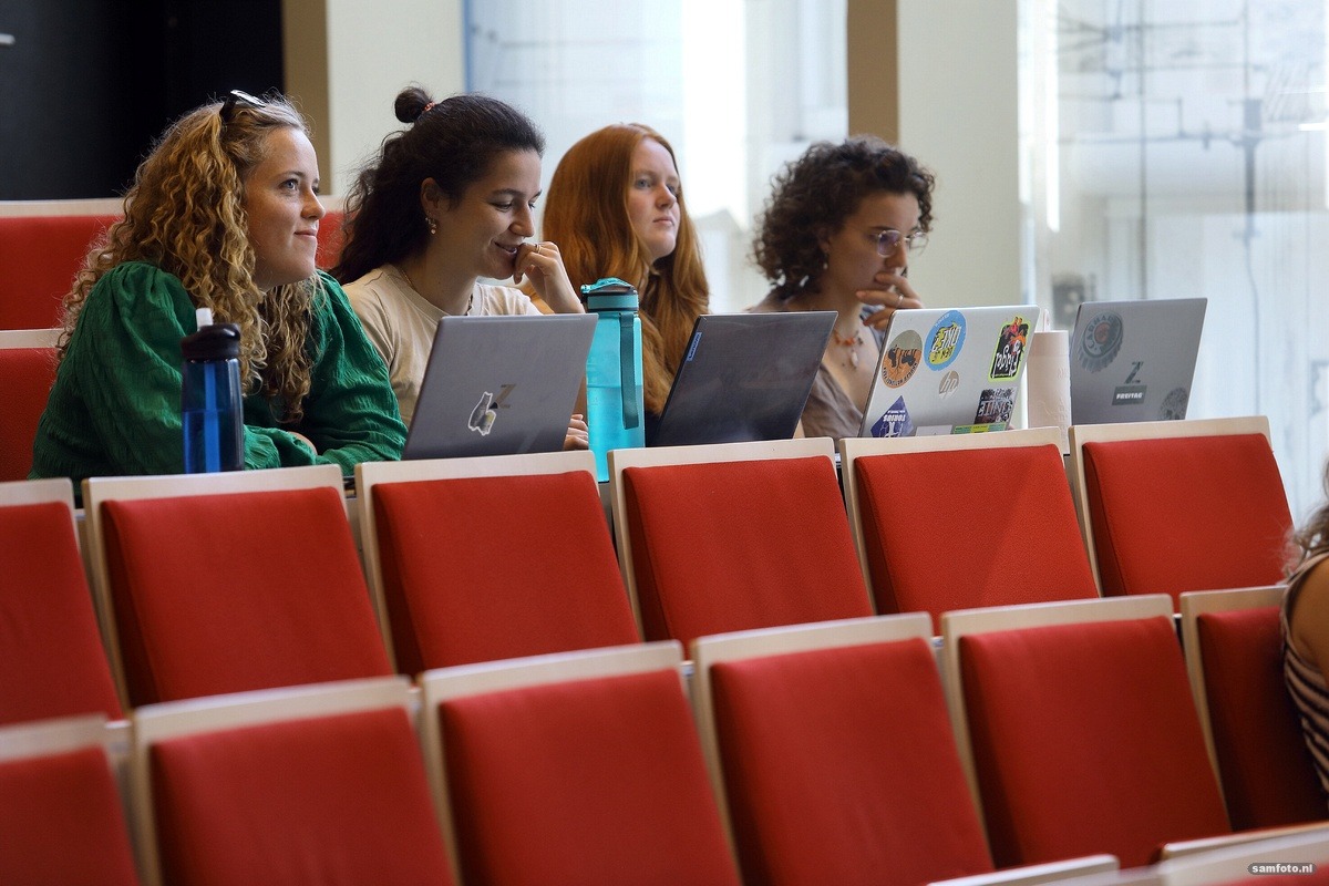 Studenten hbo en wo maken zich meer zorgen over milieuvervuiling Vier studenten zitten op een rij in een collegezaal, laptops opengeklapt voor zich