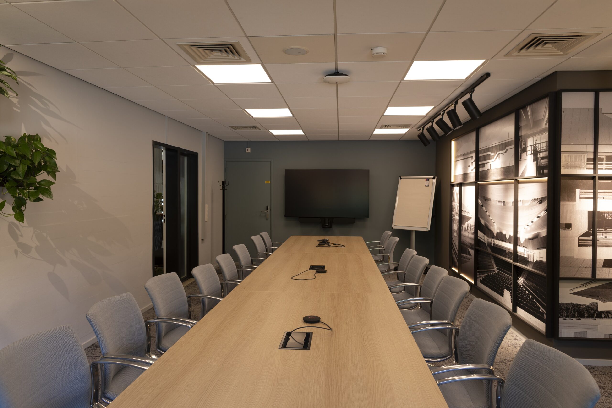 Executive Board puts plan for closed meetings with unions on hold Een vergaderkamer zonder mensen met een lange tafel en grijze stoelen