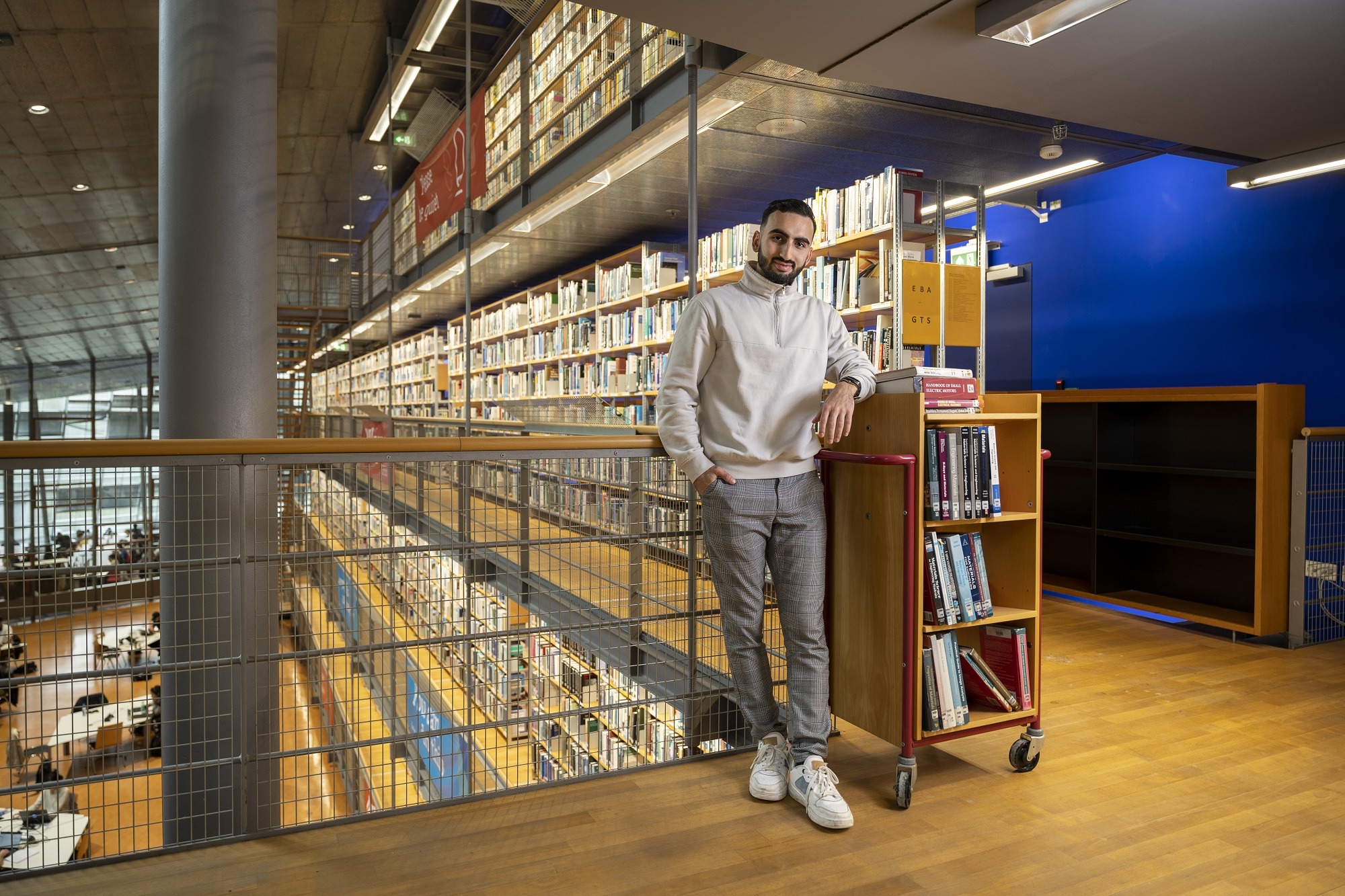 Alihan Uzun poseert in de bibliotheek