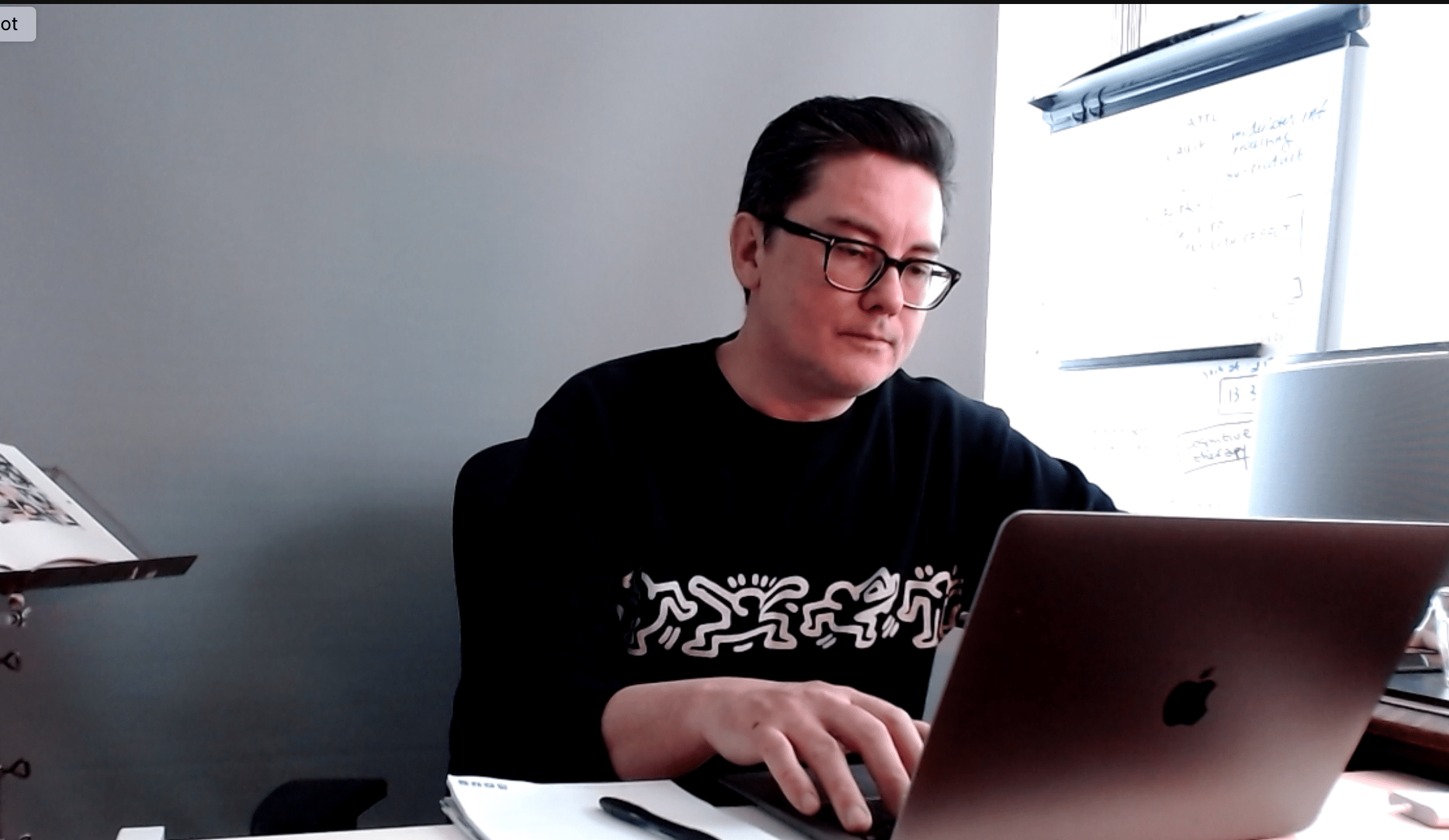 Tim Djedilbaev zit achter een laptop aan een bureau