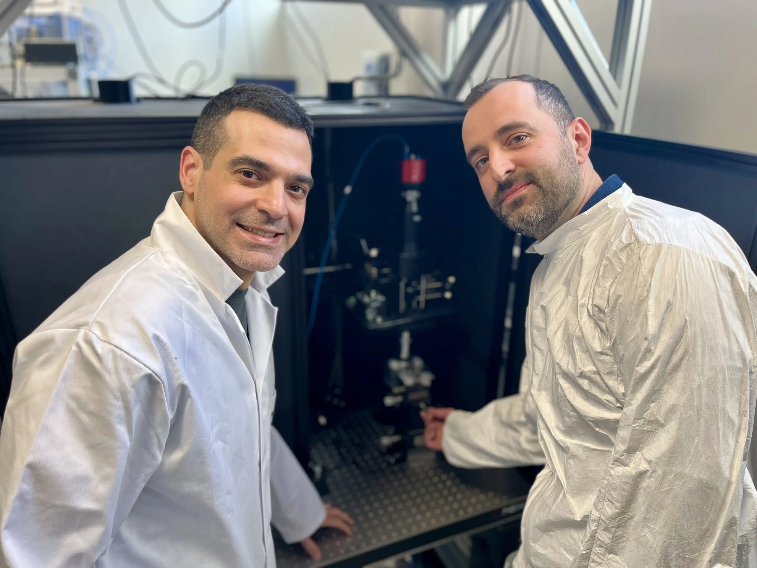 Farbod Alijani en Aleksandre Japaridze (werktuigbouw) voor een experimenteel prototype van het apparaat waarmee ze luisteren naar bacteriën. (Foto: Delta/Edda Heinsman)