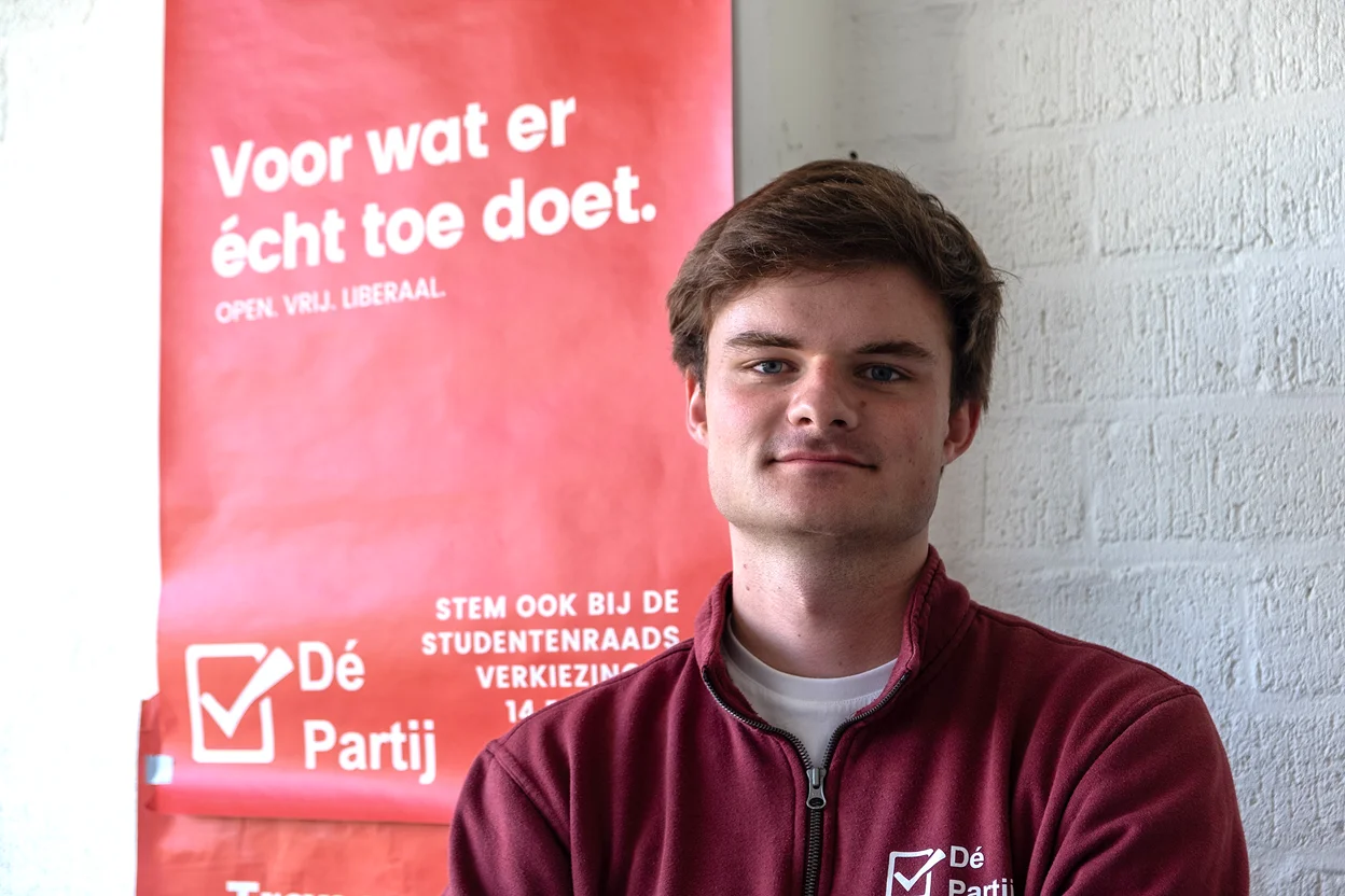 Een portret van Koos Meesters, met achter zit een poster van De Partij.