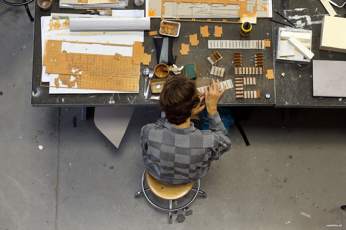 Architecture had working conditions investigated; report highlights structural problems Bovenaanzicht van een student die aan het werk is in de maquettehal van de faculteit Bouwkunde